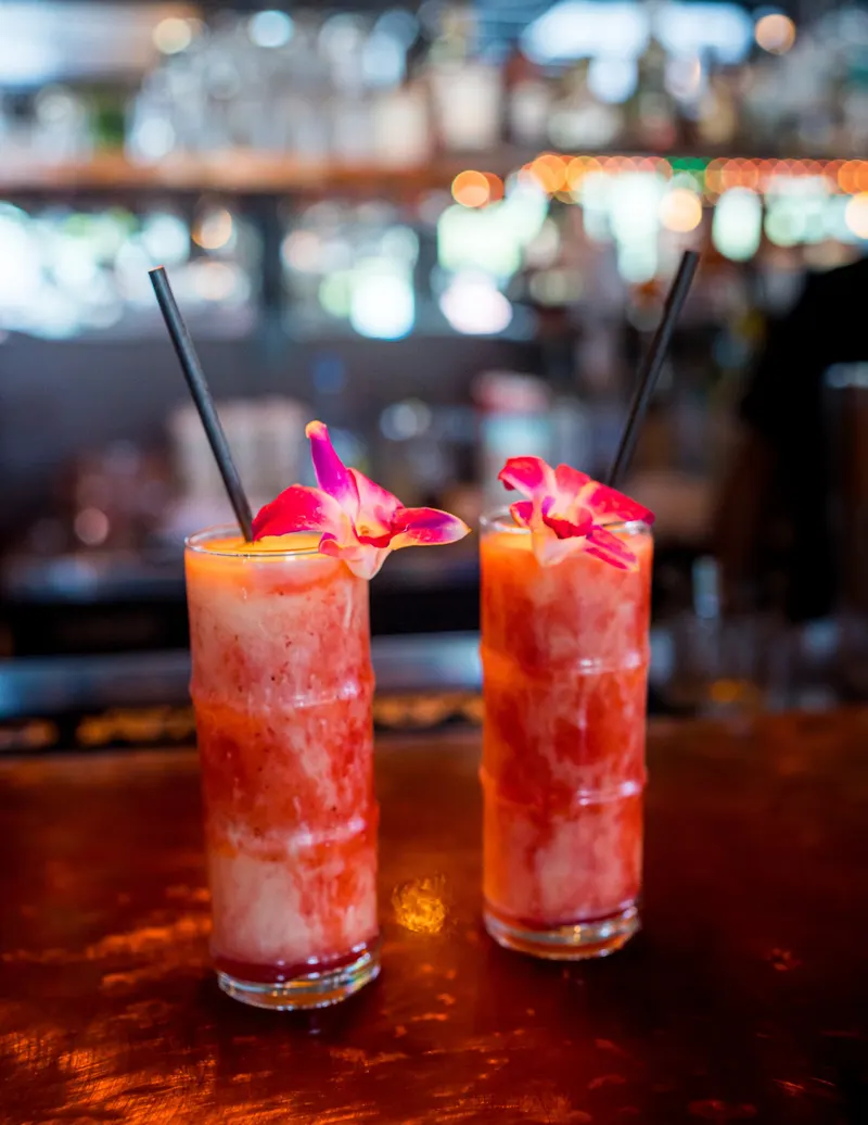 Two Lava Flow cocktails garnished with orchids